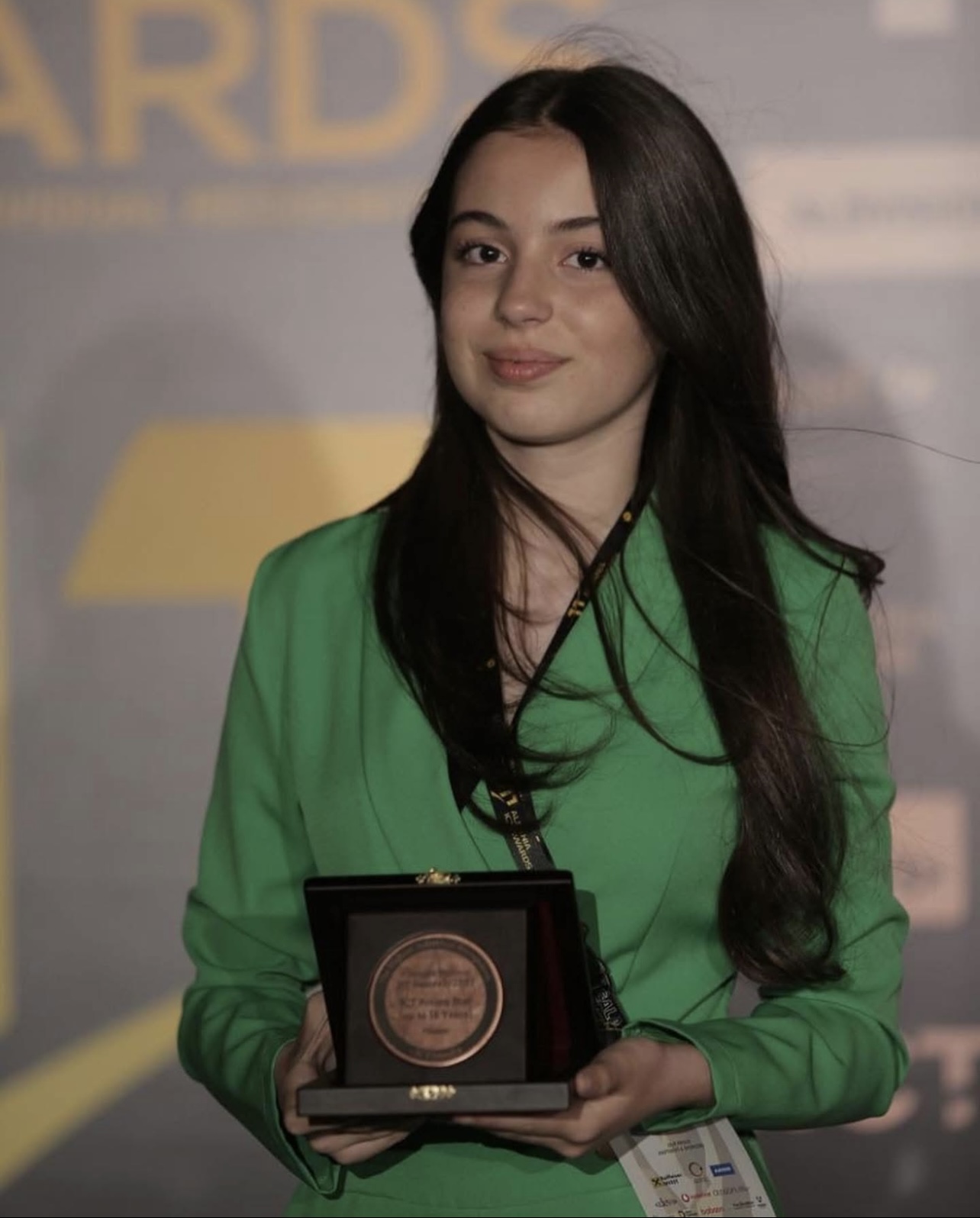 Orhidea Ollogu holding an award