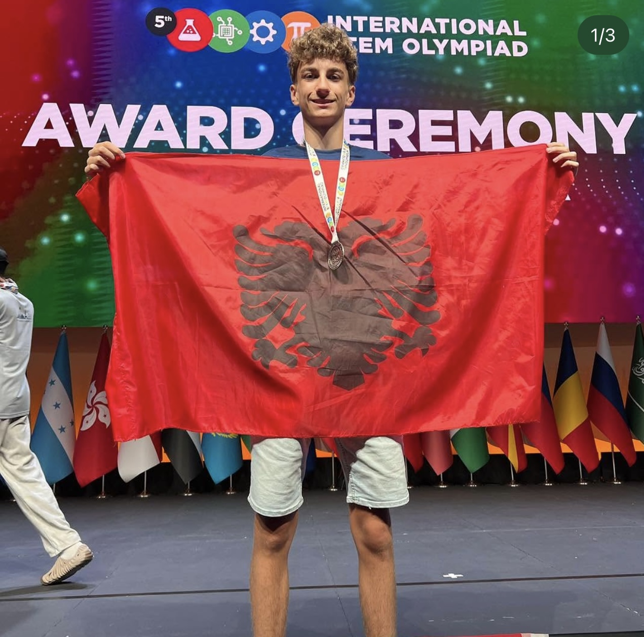 Eugen Papraniku holding the Albanian flag at the International STEM Olympiad